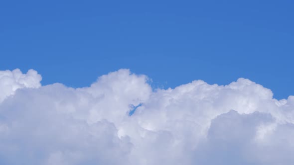 Time lapse of beautiful scenic fasting fluffy cumulus clouds in sunny day, medium shot