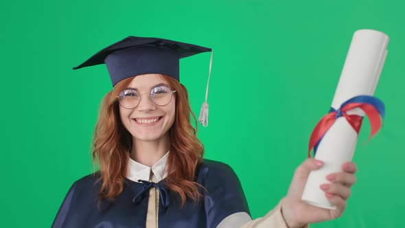 Young Woman with Glasses for Vision is Having Fun and Rejoices at Graduation Holding Diploma in