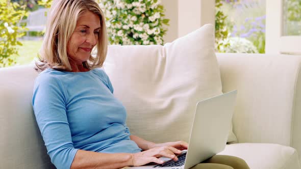 Senior woman using laptop in living room