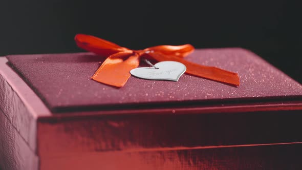 Valentine's Day Concept, Close Up of Beautiful Shining Gift Box with Red Ribbon and Heart Shaped Tag