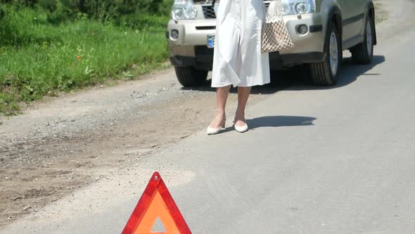 Business woman waits for assistance near her car broken down on the road side