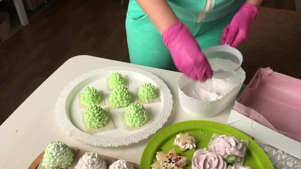 The Woman Sprinkles The Marshmallow With Powdered Sugar.