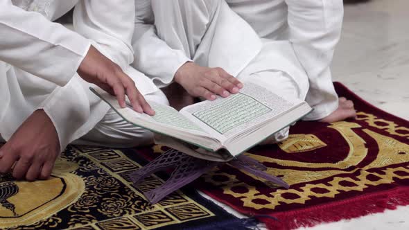 Muslim men reading Quran