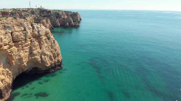 Vast turquoise ocean bared by Steep eroded cliffs in Lagos coast, Algarve, Portugal
