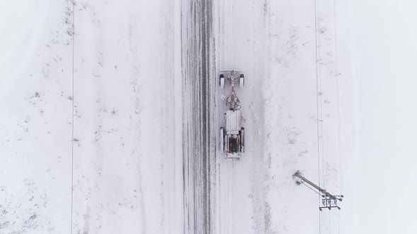 Top down Aerial view of Snowblower Grader Clears Snow Covered Country Road 07