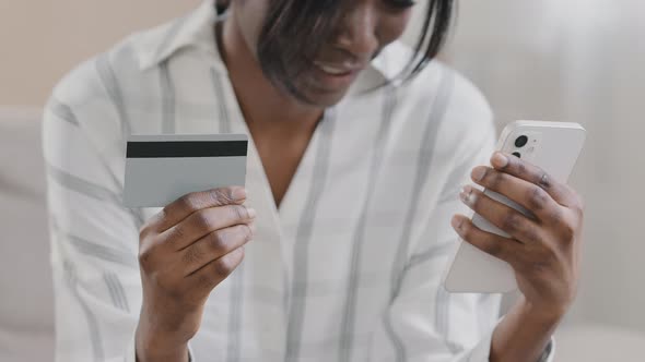 Closeup Young Happy Woman Shopper Making Purchase in Online Store Using Smartphone Holds Credit Card