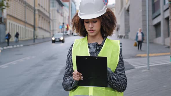 Portrait Young African American Beautiful Female Engineer Wearing Safety Vest and Hardhat Standing