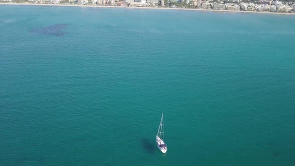 Sailboat in turquoise water In Mallorca. Drone shot in coast of Balenario.