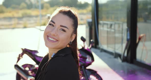 Brunette with Ponytail Looking at Camera with Sincerely Smile on Self-Service Car Wash