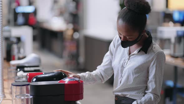 Young Afroamerican Woman in Kitchen Appliances Store Young Female Shopper is Choosing Automatic