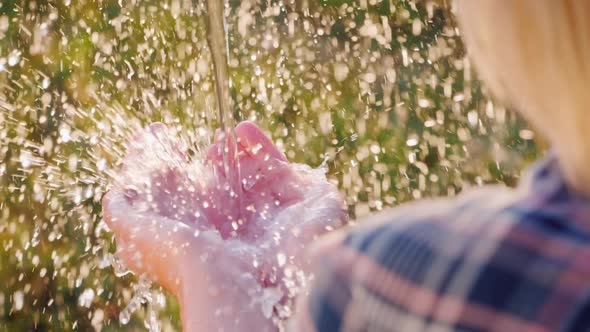 Back View A Jet of Water Splashes on Human Palms. Clear Water Concept