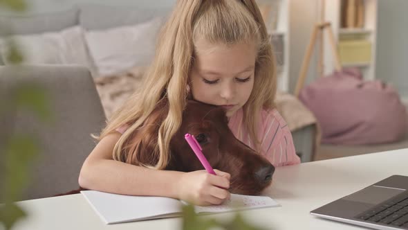 Girl with Dog Writing in Copybook