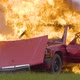 A red car explodes in an open field. The car is on fire. - VideoHive Item for Sale