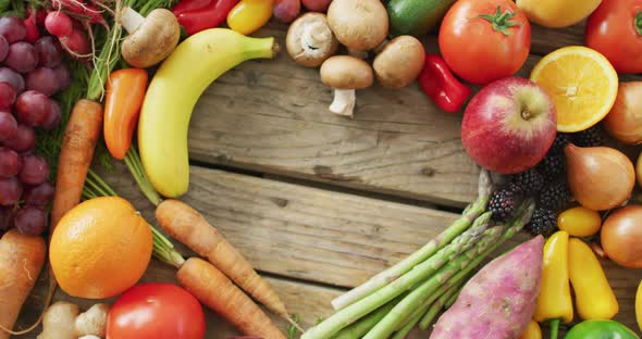 Video of fresh fruit and vegetables with heart shaped copy space over wooden background