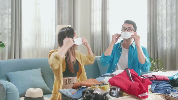 Asian Couple Travelers Packing Clothes And Protect Mask In A Suitcase For A New Journey