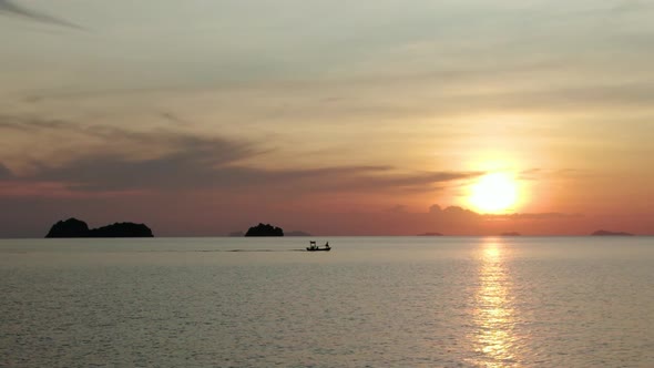 Boat cruising in the ocean in Ko Samui, Thailand during a beautiful sunset. Aerial view