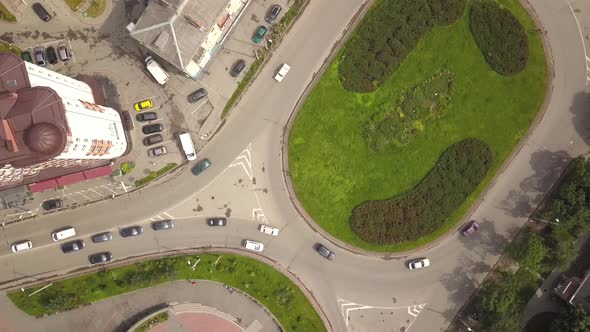 Top down aerial view of roundabout street intersection with moving cars traffic.