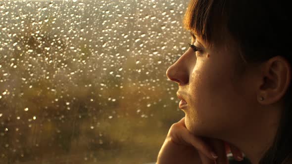 Woman Sitting Alone Close To Window with Rain Drops