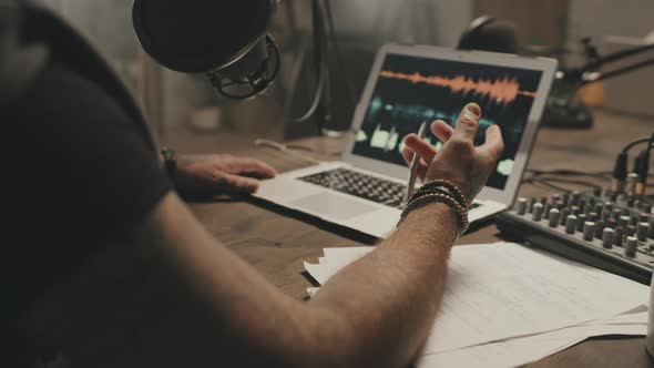 Unrecognizable Podcast Host Talking Into Microphone