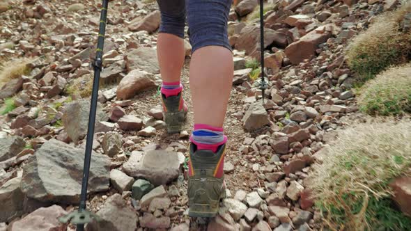 Close up of walking feet with heavy boots on a hike in rocky terrain, Morocco