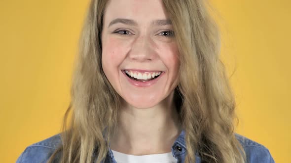 Young Smiling Pretty Girl on Yellow Background