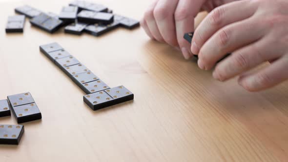 Caucasian woman sick with parkinson's disease play dominoes.