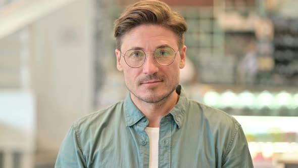 Portrait of Serious Middle Aged Man Looking at Camera 