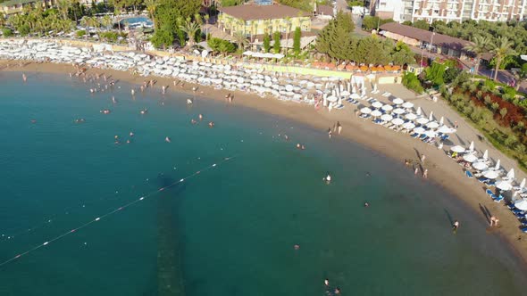 People Bathing in the Sun, Swimming on the Beach. Aerial View of Tourists on the Sand Beach.