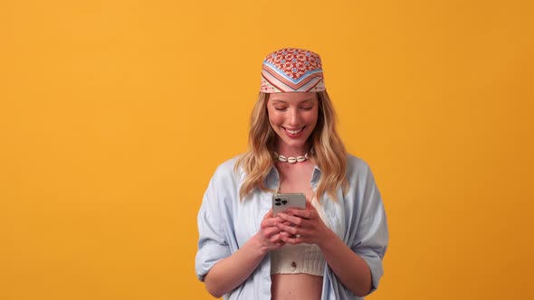 Smiling blonde woman hippie texting by phone