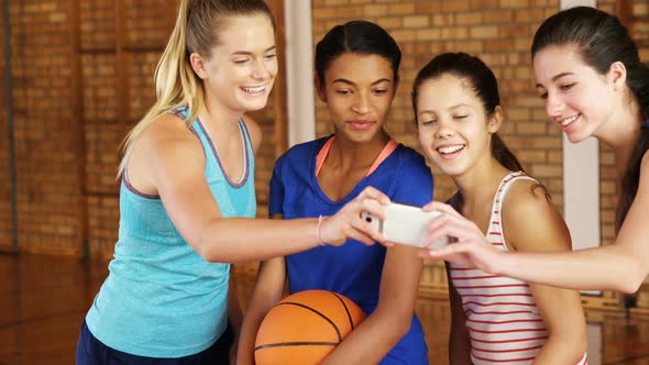 Happy high school team taking a selfie with mobile phone