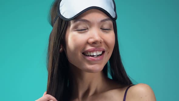 Flirty Asian Lady Wearing Eye Mask and Sending Air Kiss Into Camera, Good Mood