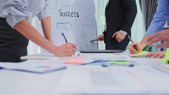 Asian businessman gives report on whiteboard to colleague team then brainstorm for new project