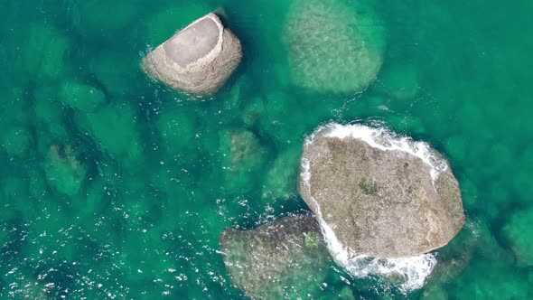 Aerial view Drone camera of seashore rocks in ocean. Beautiful dark sea surface. Amazing sea waves