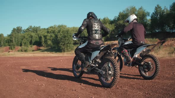 Two Men Riding Away on Motorcycles