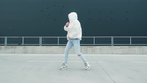 Fashionable Dancer Man in Sportswear and with Glasses Is Performing Outdoor Street Dancing Motion