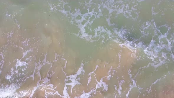 Waves View From Above. Sea Waves Over a Sandy Beach. Top View. 4K Video