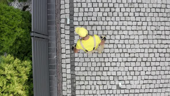 Construction Worker Paving Brick Driveway