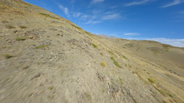 Helicopter Flying Over Desert Steppie Hilly Terrain with River and Yellow Green Spruce Forest Trees