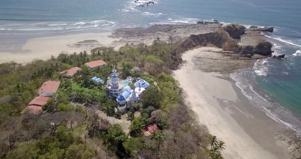 Aerial drone view of the beach, rocks and tide pools in Guiones, Nosara, Costa Rica