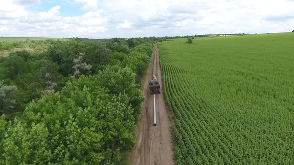 Gorgeous Landscape View of a Field with a Road and an Excavator Moving a Pole