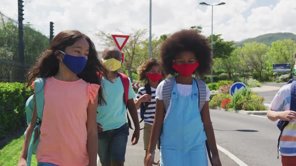 Group of kids wearing face masks walking on the road