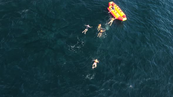 Happy People Swim on Air Mattress Behind a High Speed Water Bike