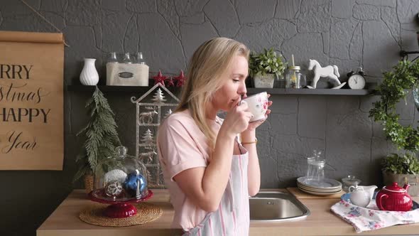 Happy Young Woman with a Cup of Tea Over Christmas Table Background. Awaiting the Holiday.