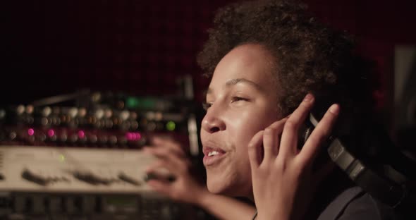 Happy Black Woman Singing Near Soundboard