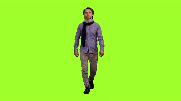 Elegant Man in Shirt with Blue Scarf Walks on Green Background