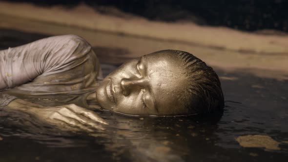 The Woman Is in the Water Covered All Over with Gold Paint