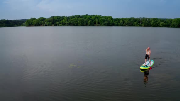 Aerial view of man paddling on SUP board on large river