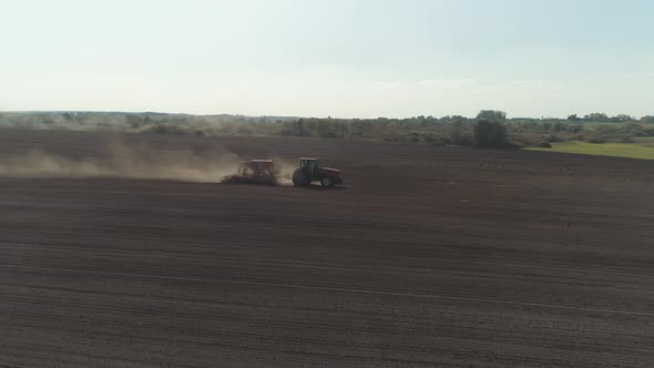 Countryside and Agriculture, Farm Tractors Plow the Earth in Field, Dust in the Field, View From