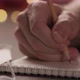 Slow Motion Closeup Man Writes Shopping List in Notepad with a Pencil Under Warm Light in the - VideoHive Item for Sale