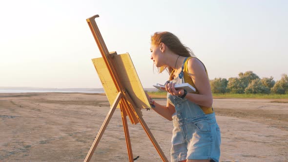 Young Woman Artist Painting Landscape in the Open Air on the Beach
